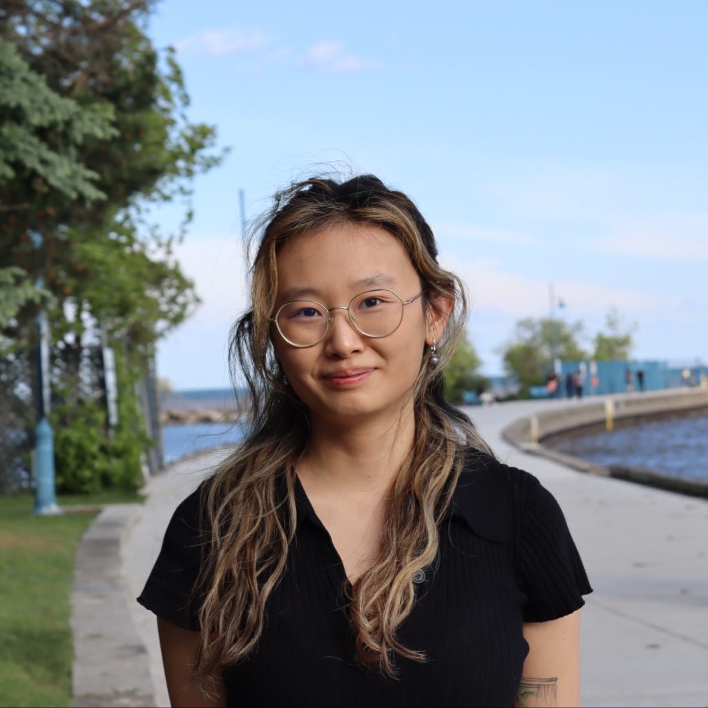 Heather smiling in front of a pier.